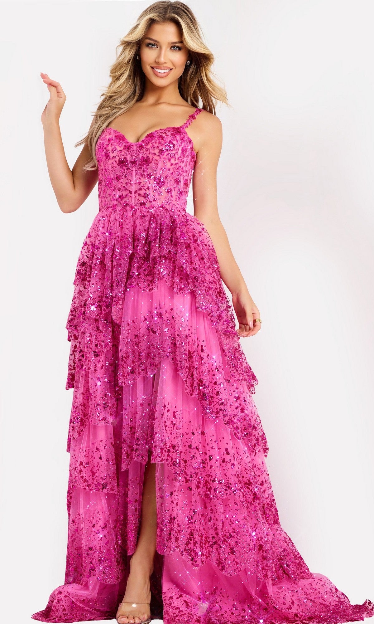 A woman poses and smiles against a white background wearing the Jovani 47320 Long Prom Dress in fuchsia, featuring sequins, spaghetti straps, and a floor-length design.